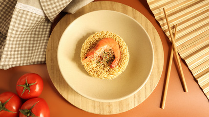 Spicy instant noodle soup with shrimp and vegetables. shrimp soup, cooking, food. Raw dried circle-shaped vermicelli in a plate. pasta, for the preparation of which it is enough to pour boiling water