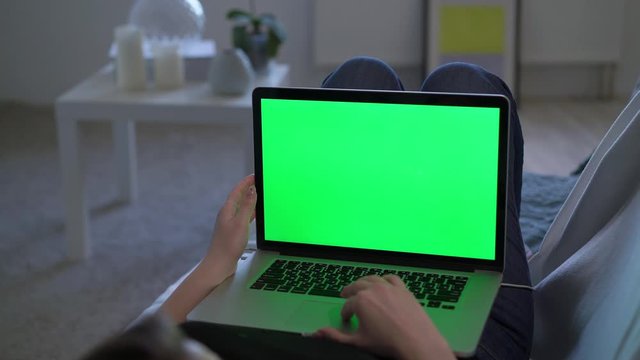 Woman working or using laptop computer with green screen chromakey display