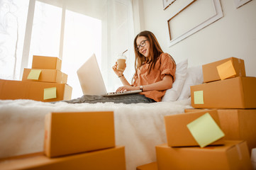 Young woman asian work from home talking with customers to sell products online and delivery for customer. Business owner, SME, shipping, work from home(WFH), freelance, Start up concept.