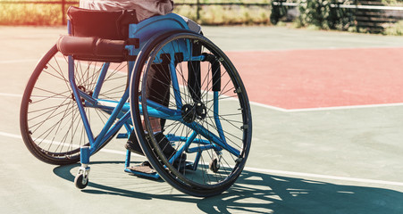 Basketball player on wheelchair at the basketball court. Sports motivation and will concept.