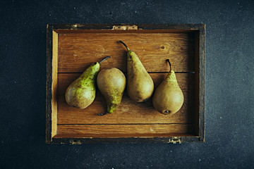 Conference pears on a rustic wooden board. Flat lay. Still life