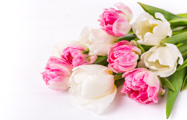 Fototapeta premium Beautiful tulips on white wooden background