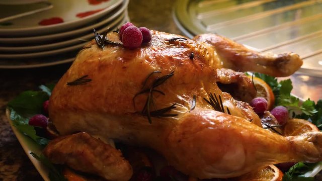 roasted chicken with rosemary and cranberries on serving plate 