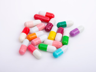 Different color pills on white background