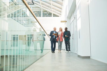 Business colleagues walking along the office corridor to the business meeting
