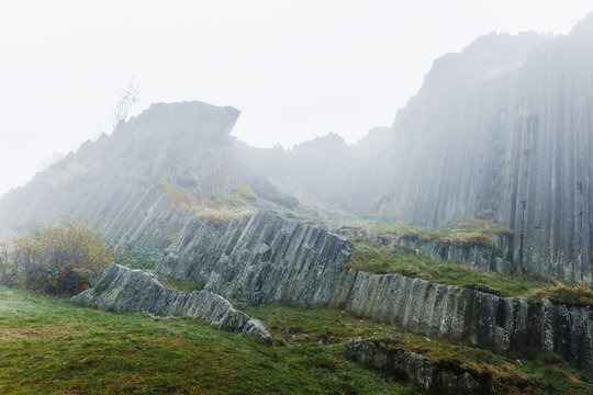 Mystical location near basalt mountain in fog. Geological nature and travel destination.  - Powered by Adobe