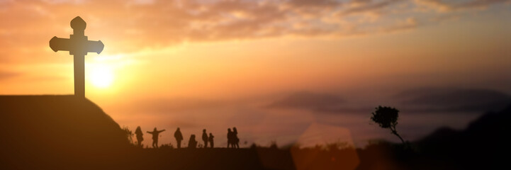 Fototapeta na wymiar Silhouette of group people looking for the christian cross at sunset background. Idea for worship or praise god. panorama picture