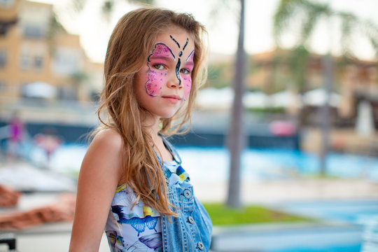 face painting pink butterfly on little girl 