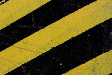 Warning painting of a post in a warehouse. Sign of attention for transport from yellow and black stripes.