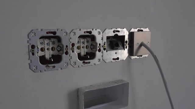 Uninsulated electrical socket and 8P8C RJ45 jack connector in unassembled state during renovation or repairs of apartment. AC power plugs Europlug Type C CEE. Insecure, unsafe and dangerous situation