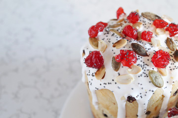 Traditional Easter cake with icing, berries and pumpkin seeds. Space for text