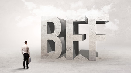 Fototapeta premium Rear view of a businessman standing in front of BFF abbreviation, attention making concept