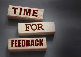 Time fir feedback text on wooden blocks. Product or service evaluation and clients feedback in...