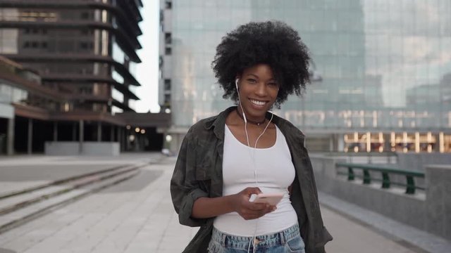 happy young attractive girl walks smiling listening to music on the phone