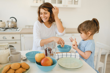 A young mother spends time with her little daughter at home.