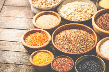 Organic products. Bowls with different gluten free grains on wooden background