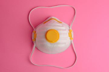 Protective face mask on a pink background. Close-up, top view.