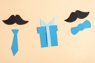 Top view of paper crafted fake mustache and decorative elements on beige background, fathers day concept