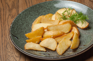 fried potatoes with dill in a plate