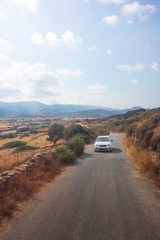 Car driving along rural road on Greek island of Naxos