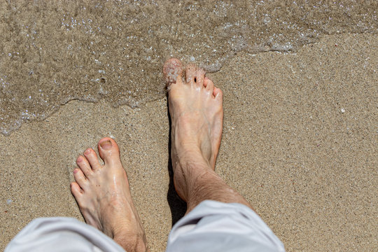 top down view of male feet waiting for a wave to come in, oh the anticipation copy space too.