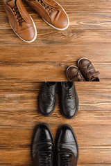Split image with mens and childrens brown and black shoes on wooden background, fathers day concept