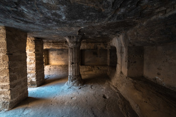 The stone pillars and meditation chambers inside the ancient rock cut Buddhist caves in the Uparkot Fort in the city of Junagadh in Gujarat, India.