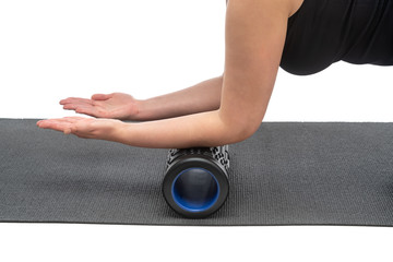 A middle-aged woman on a myofascial roller makes a hand massage on a white background.