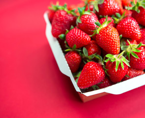 Bright juicy selected strawberries in a portioned cardboard box.