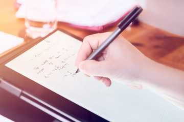 Young university professor is doing online lecture for his students from home during lockdown. He is using 2 in 1 convertible laptop and is writing math formulas with stylus pen