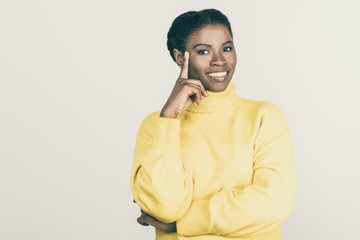 Happy young woman smiling at camera. Beautiful smiling young African American woman standing with hand on face and looking at camera isolated on white background. Dream concept