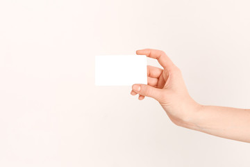 Fototapeta premium A beautiful female hand holds a Bank credit card with an online service, after completing the documents.