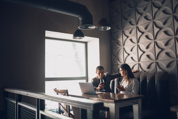 Cheerful man and woman talking, enjoying at the wine shop, cafe. Couple or friends, business partners drinking toghether, sitting at the table in casual attire, dating. Communication, relations