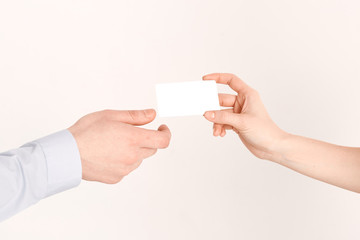 The girl's hand passes the credit card to the man's hand. Purchase of a plastic card with an online service close-up.