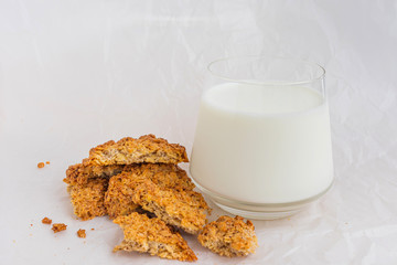 Homemade oatmeal cookies and a glass of milk on a light background. The concept of breakfast, homemade natural food.
