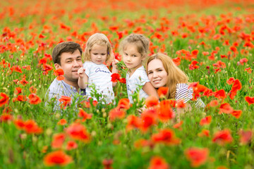 beautiful happy family standing in poppy field