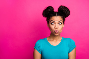 Closeup photo of beautiful pretty dark skin lady two buns hairdo look side empty space send air kiss tricky mood interested wear blue casual t-shirt isolated vivid pink color background