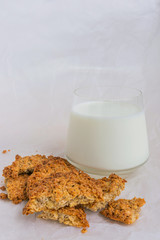 Homemade oatmeal cookies and a glass of milk on a light background. The concept of breakfast, homemade natural food.