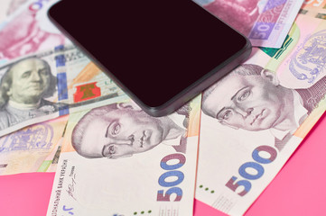 Smartphone and different money on pink background. Concept of mobile banking. Online shopping from home. Distancing control financial balance