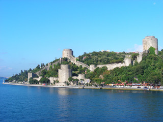 Fototapeta premium A fort with two towers and a defensive wall on an island in the sea.