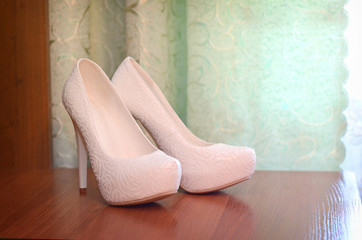 White wedding shoes on wooden surfaces