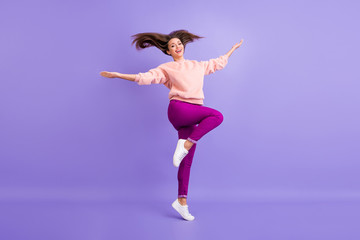 Fototapeta na wymiar Full body profile photo of funny lady jumping high up rejoicing spend lovely time throwing long hair up wear casual fur soft sweater pants sneakers isolated purple color background