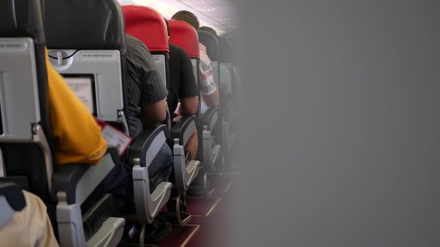 Interior of airplane with passengers on seats. View inside in plane. Long and boring flight