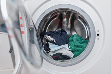 Offene Waschmaschine mit Mundschutz Maske, mit W&auml;sche