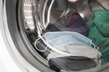 Einmal-Mundschutz in Waschmaschine, geschlossen mit Wäsche