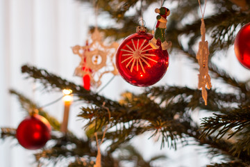 red christmas tree ball on fir branch with lights