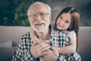 Closeup photo of funny two people old grandpa little granddaughter sitting sofa stay home...
