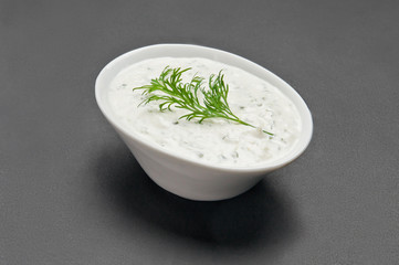 White ceramic bowl with white souce on grey background