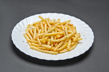 White ceramic plate with French fries on grey background