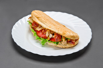 White ceramic plate with big tasty grill sandwich on grey background.